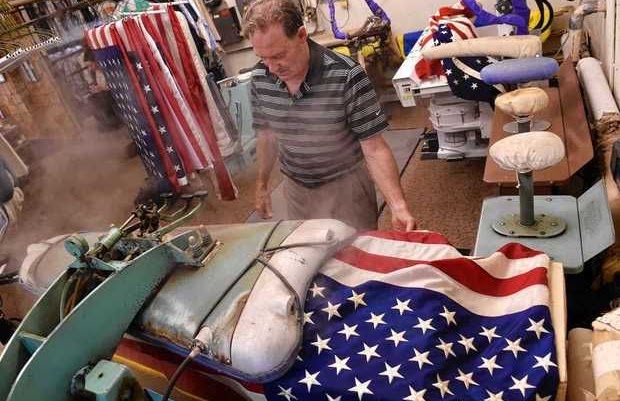 John Ritter uses a vacuum steam press inside Ritter's Cleaners